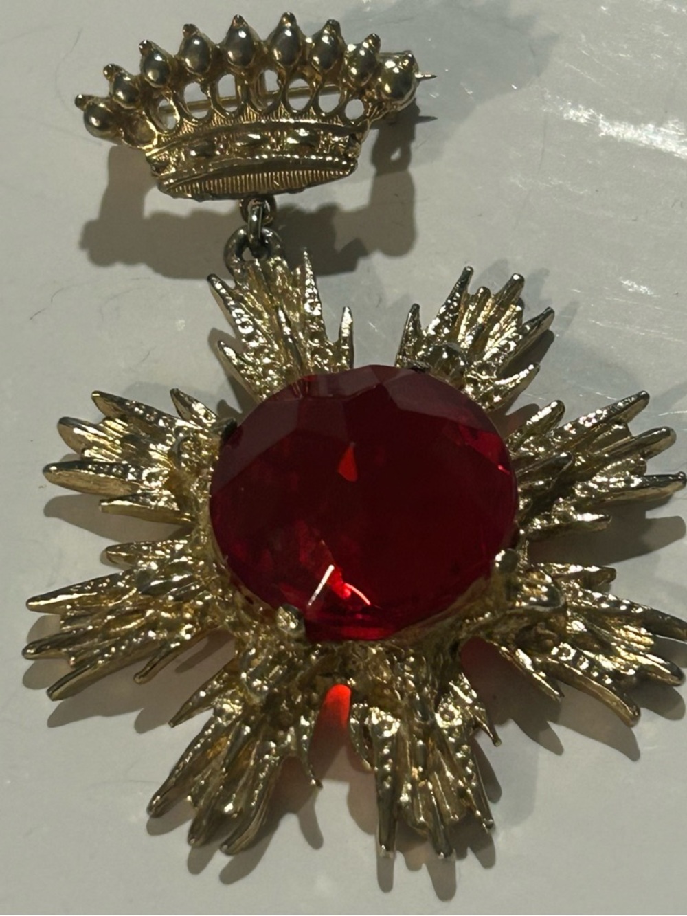 Gold-Tone Brooch with Ruby Red Crystal Starburst and Crown Accent